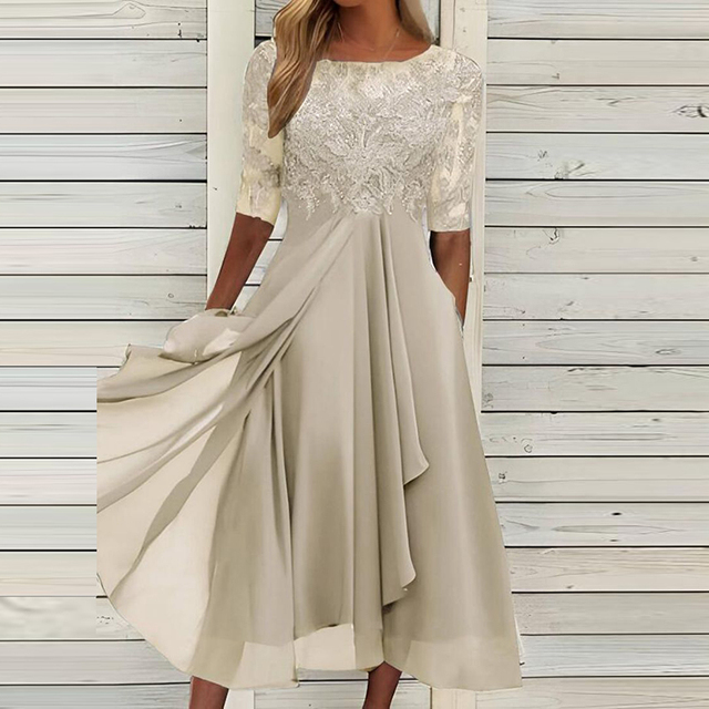 Abito elegante donna beige, maniche corte in pizzo, gonna fluida, sfondo legno chiaro. Moda femminile, abbigliamento cerimonia, stile sofisticato.