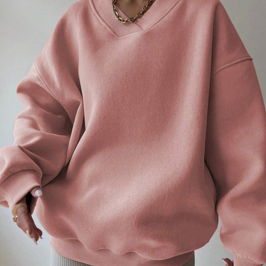 Maglione oversize rosa in cotone, indossato da una persona con collana dorata. Moda casual, abbigliamento autunnale, stile confortevole.