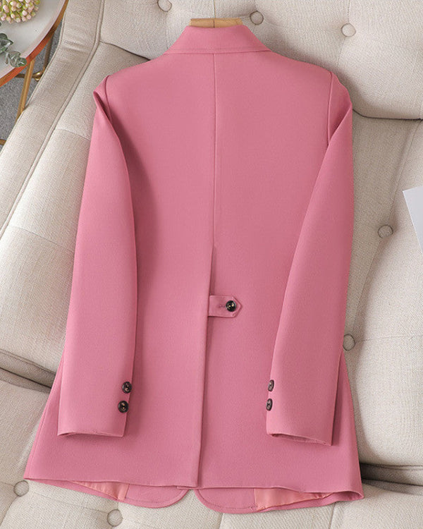 Giacca rosa elegante da donna su divano beige, design moderno con bottoni neri, ideale per moda autunnale e look formale.