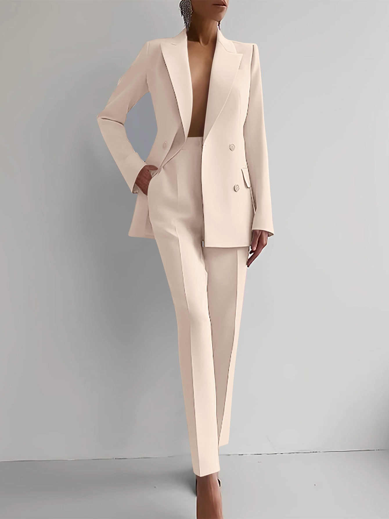 Completo elegante donna beige, giacca doppiopetto e pantaloni sartoriali. Moda femminile, abbigliamento formale, stile sofisticato.