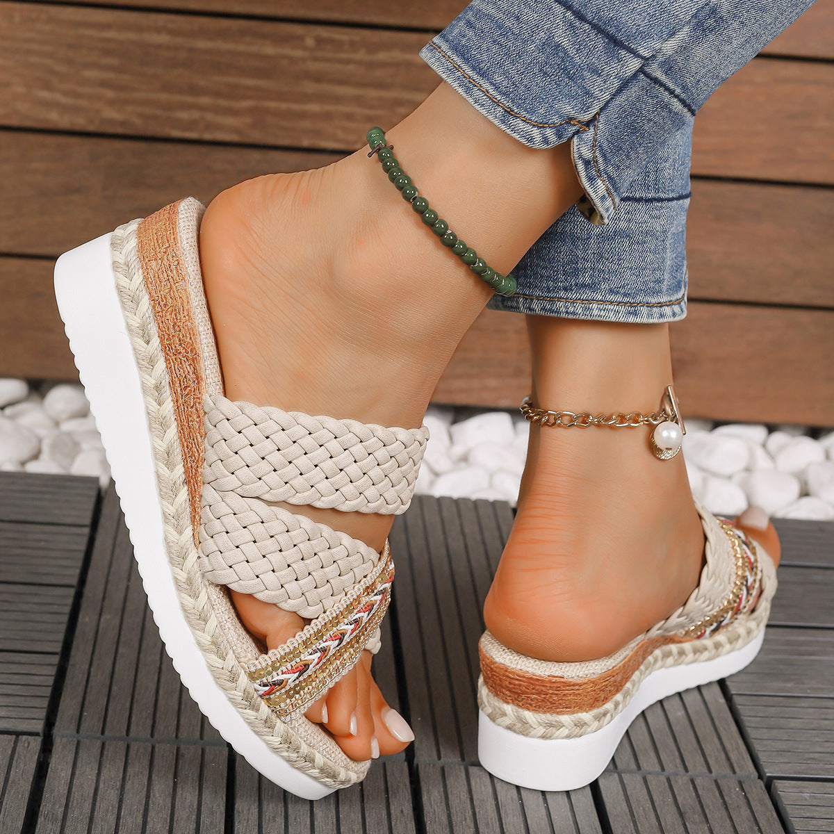 Sandali estivi intrecciati con zeppa bianca, indossati con jeans. Accessori: cavigliera verde e bracciale alla caviglia con perla. Moda casual donna.