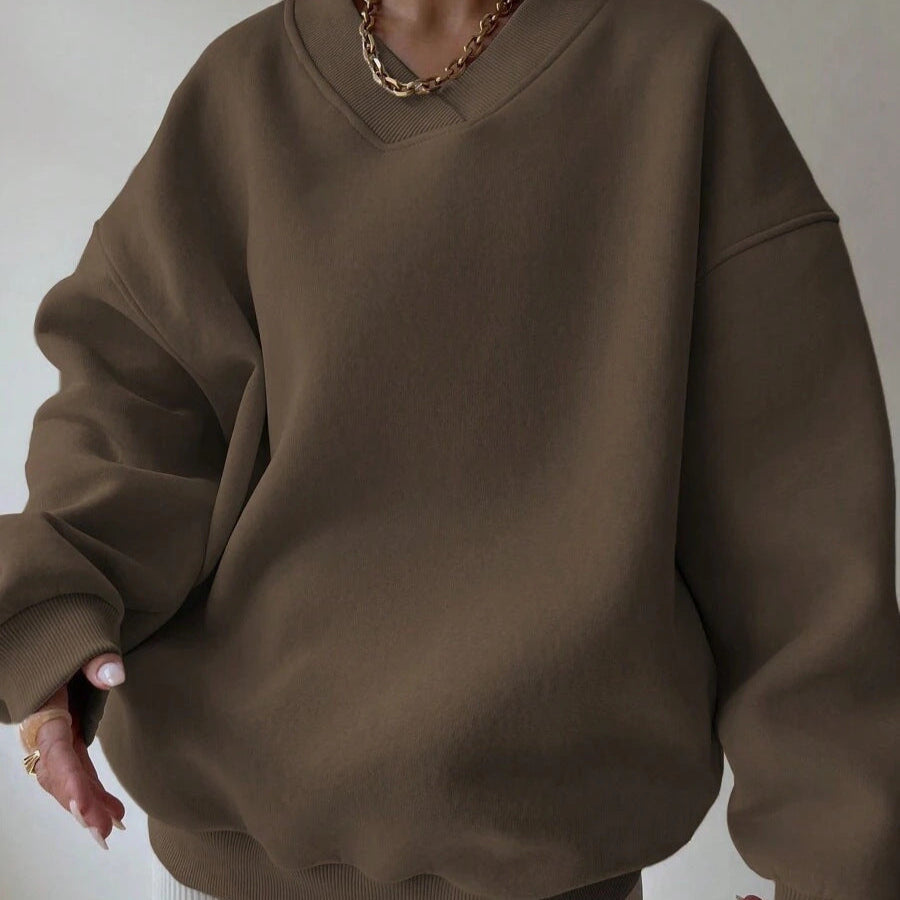 Donna con felpa oversize marrone, collana a catena dorata. Moda casual autunno, abbigliamento comodo, stile minimalista.