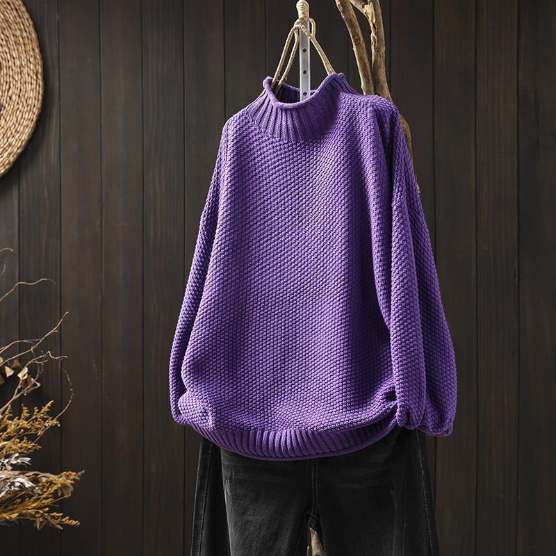Maglione viola a collo alto in maglia spessa, appeso su sfondo scuro. Moda autunnale, abbigliamento caldo, stile casual elegante.