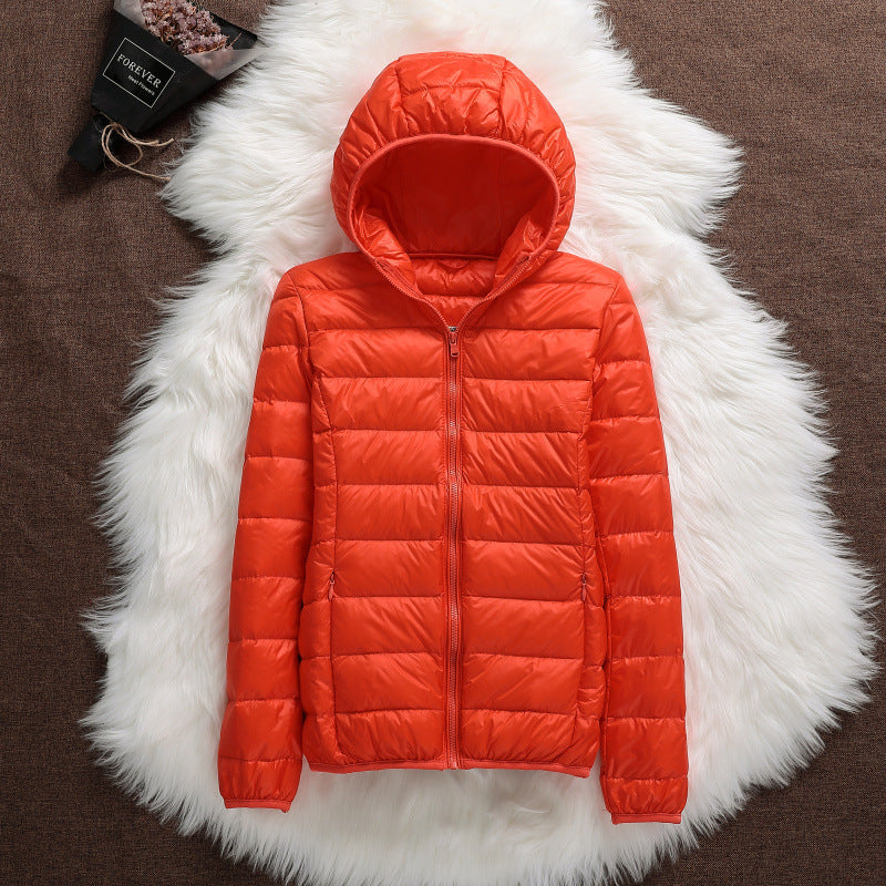 Giacca piumino arancione con cappuccio su sfondo di pelliccia bianca, moda invernale, abbigliamento caldo, stile casual, tendenza autunno inverno.