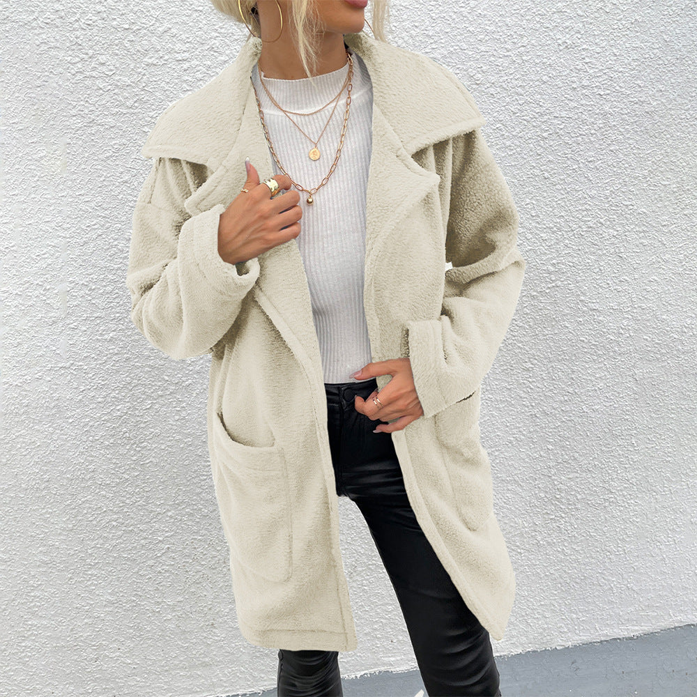 Donna con cappotto beige in pelliccia sintetica, maglia bianca e pantaloni neri. Moda autunnale, stile casual chic, tendenze abbigliamento femminile.