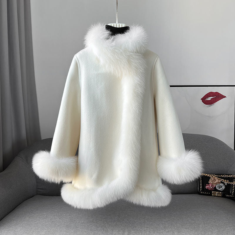 Cappotto bianco in lana con bordi in pelliccia sintetica, appeso su un manichino. Elegante e caldo, ideale per l'inverno. Moda donna.