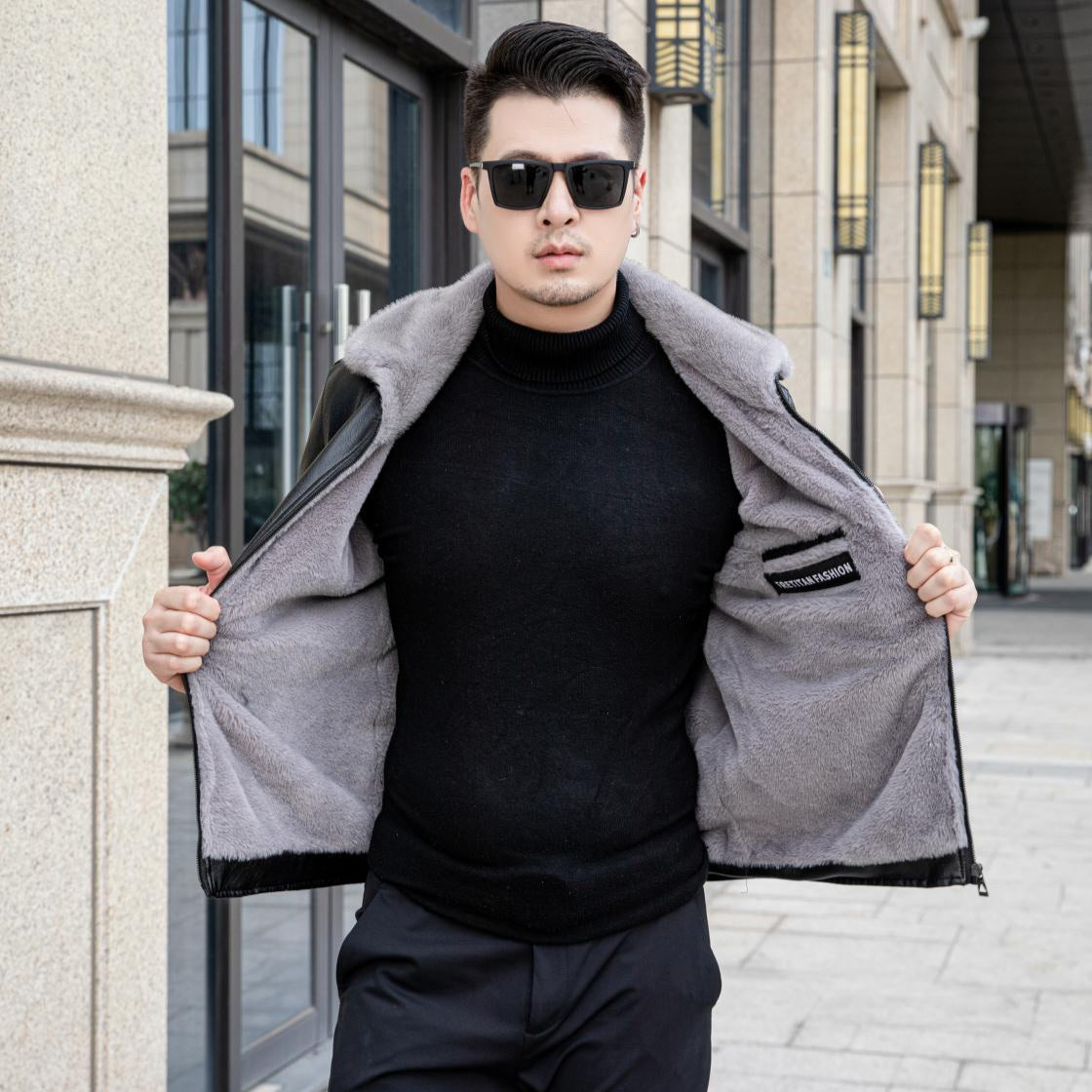 Uomo con occhiali da sole indossa giacca invernale nera con interno in pelliccia grigia, moda urbana, abbigliamento maschile elegante.