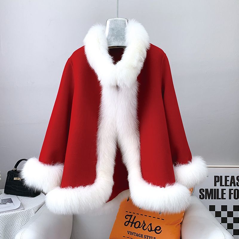 Cappotto rosso natalizio con bordo in pelliccia bianca, appeso su gruccia. Moda invernale elegante, abbigliamento festivo, stile vintage.