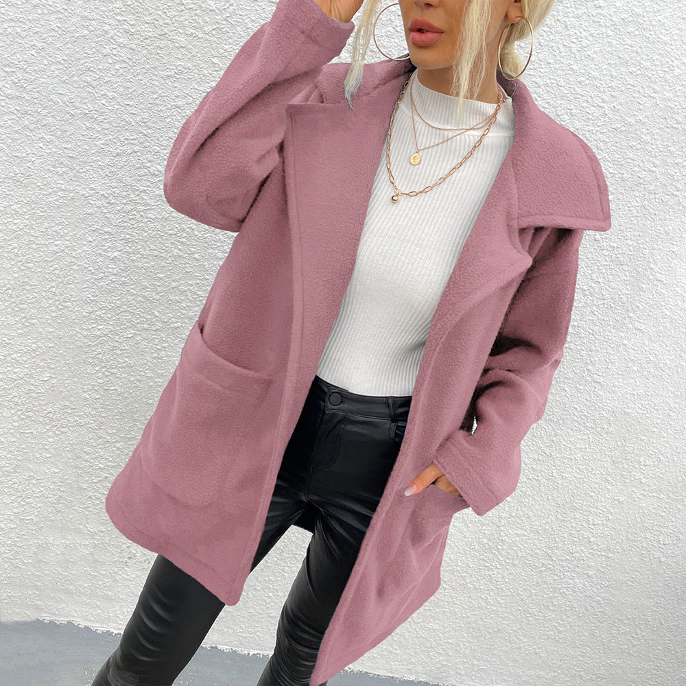 Donna con cappotto rosa elegante, maglione bianco e pantaloni in pelle nera. Moda autunnale, stile casual chic, tendenze abbigliamento femminile.