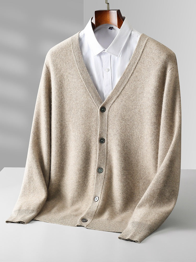 Cardigan beige in cashmere con bottoni, su camicia bianca, appeso su gruccia. Elegante abbigliamento maschile, moda autunnale, stile classico.