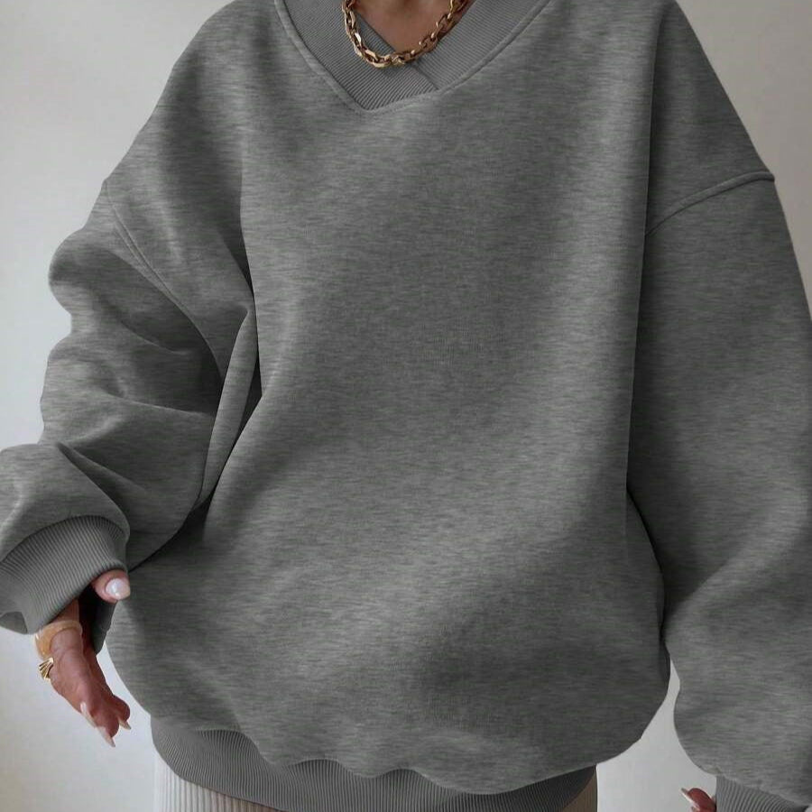 Maglione oversize grigio in cotone, indossato da una persona, con collana dorata. Moda casual, abbigliamento autunnale, stile confortevole.