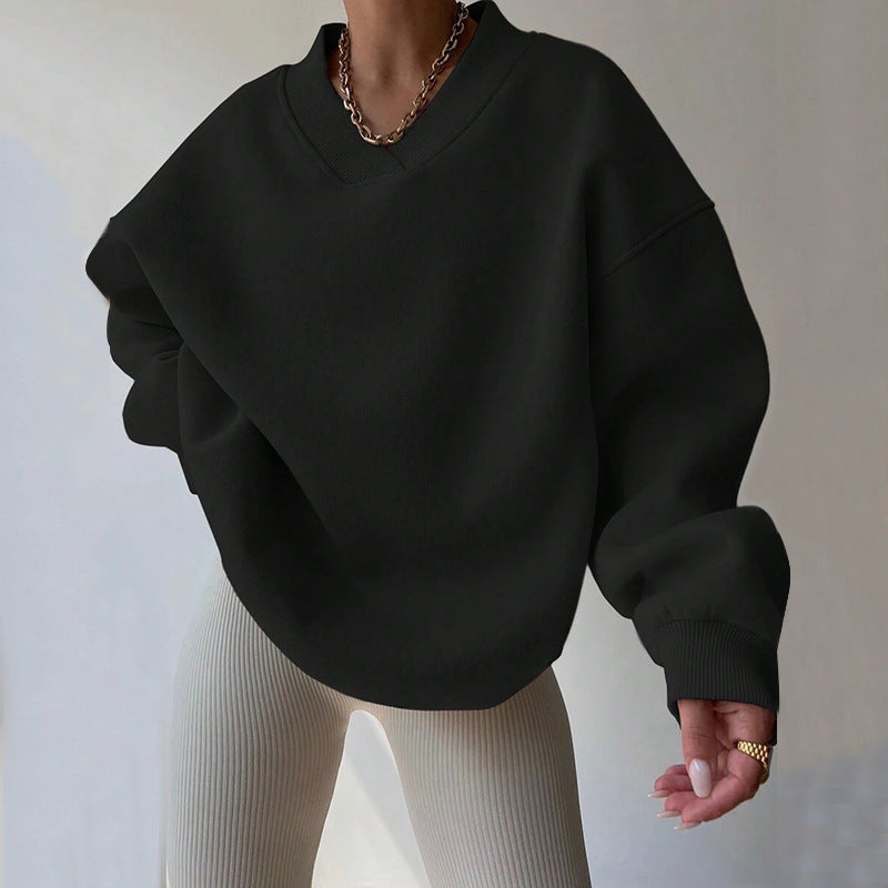 Donna con maglione oversize nero e pantaloni a coste beige. Moda casual, stile autunnale, abbigliamento femminile trendy.