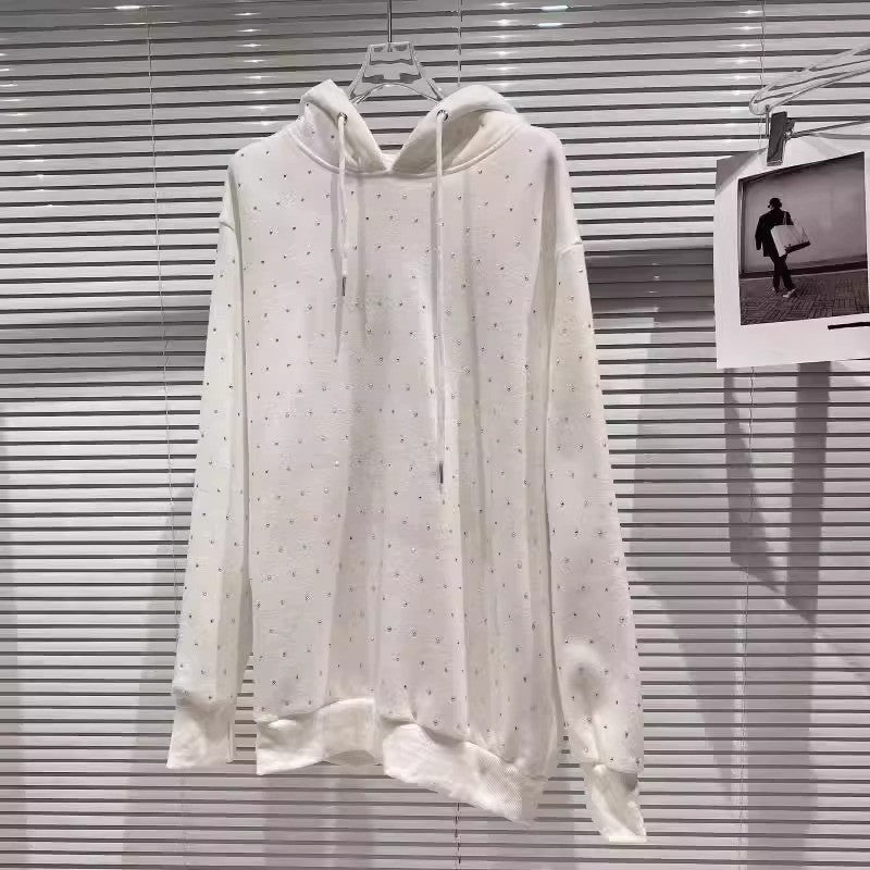 Felpa bianca con cappuccio appesa, design minimalista con piccoli dettagli, sfondo a persiane. Moda casual, abbigliamento streetwear.