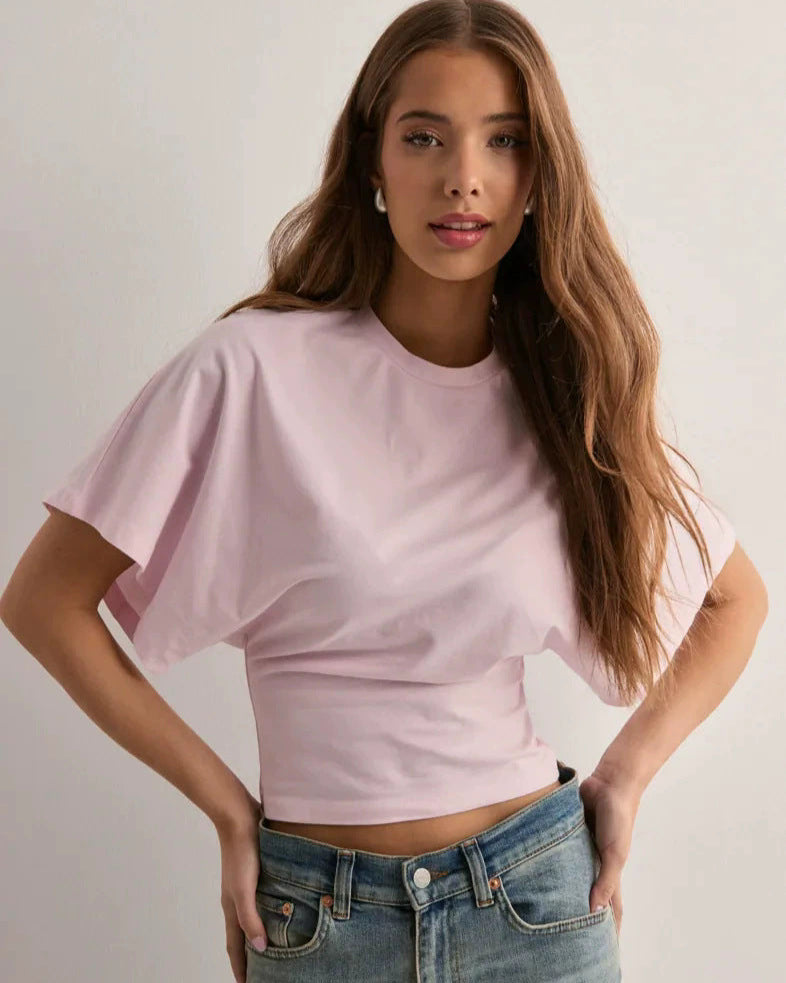 Giovane donna con maglietta rosa e jeans, posa casual. Moda femminile, abbigliamento estivo, stile casual chic, tendenze moda 2023.