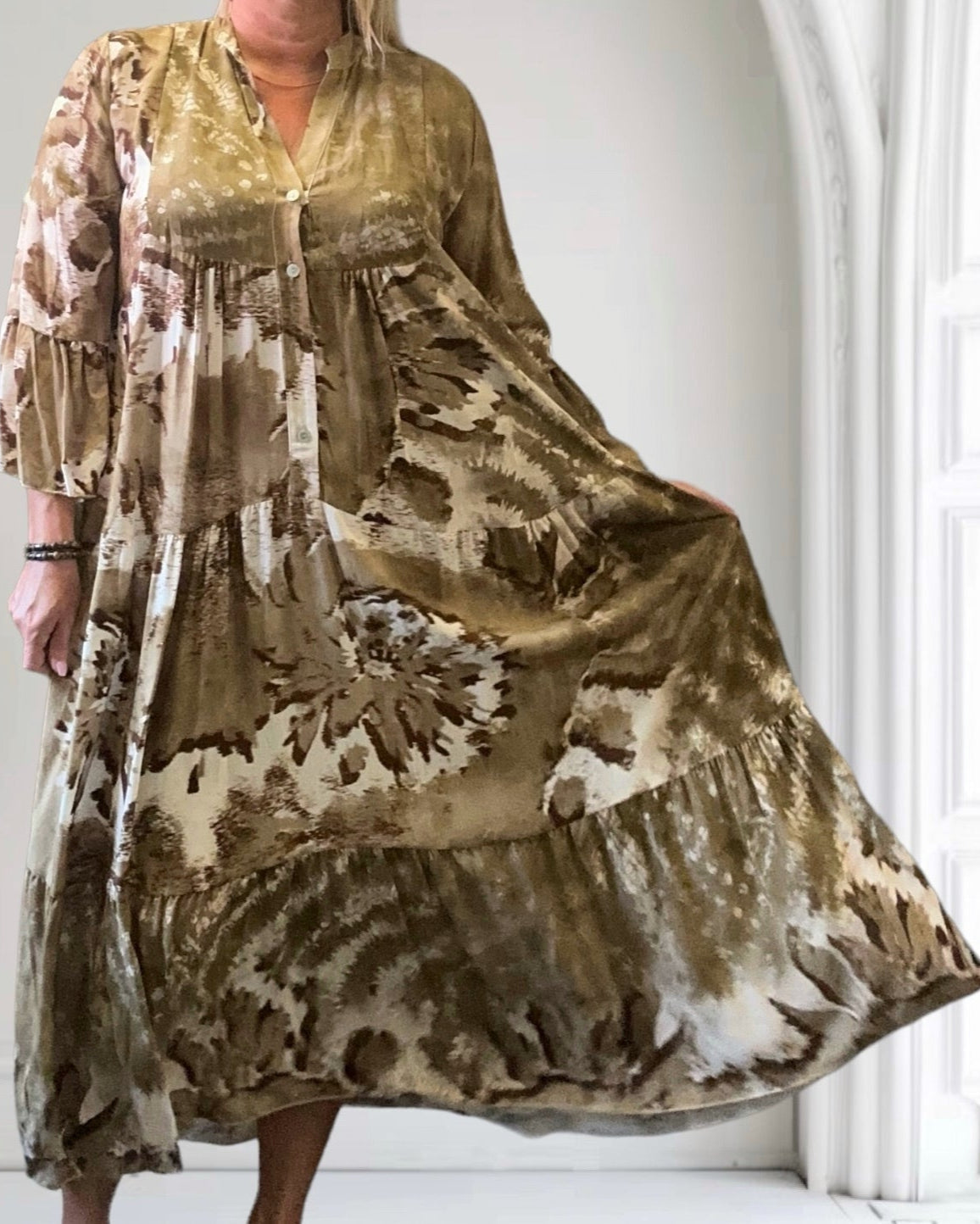 Abito lungo boho chic marrone con stampa floreale, maniche a tre quarti, sfondo bianco. Moda donna, stile casual elegante.