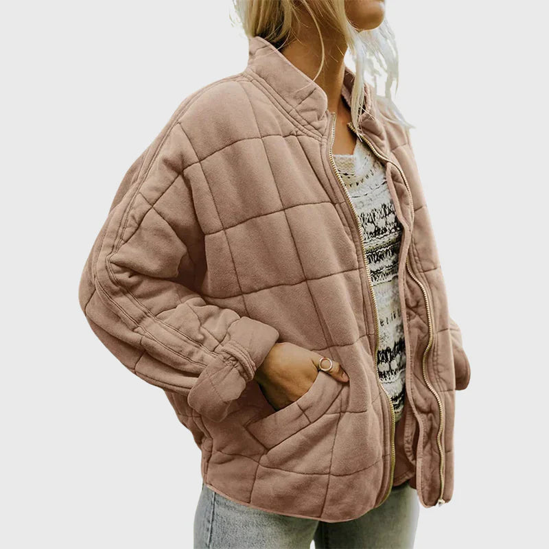 Giacca trapuntata rosa donna, stile casual, con zip e tasche, indossata su maglia bianca e jeans. Moda autunnale, abbigliamento femminile trendy.
