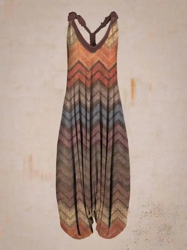Tuta lunga a righe zigzag multicolore, stile boho chic, sfondo beige. Abbigliamento estivo donna, moda casual, tessuto leggero e comodo.
