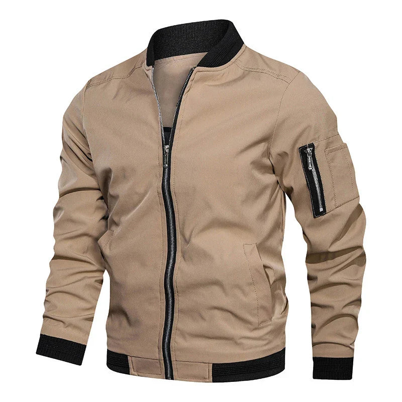 Giacca bomber beige da uomo con zip frontale, tasca con cerniera sulla manica, polsini e colletto neri. Stile casual, moda autunnale.