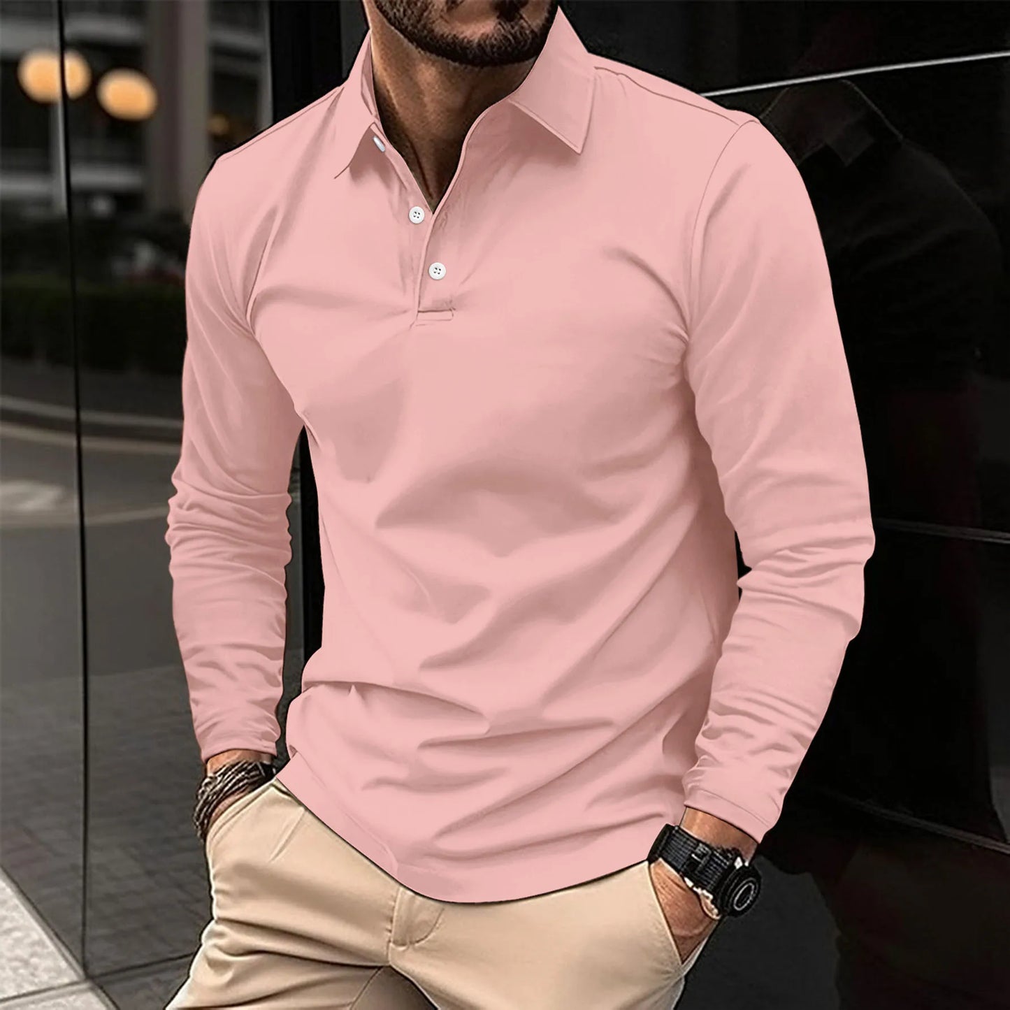 Uomo con camicia polo rosa, pantaloni beige, orologio nero, in piedi all'aperto. Moda maschile elegante, abbigliamento casual urbano.