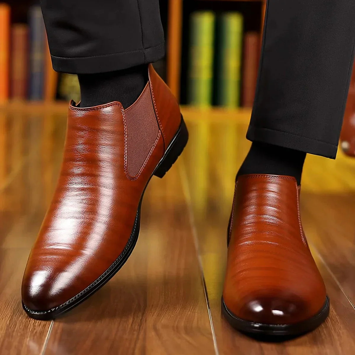 Scarpe eleganti in pelle marrone lucida da uomo su pavimento in legno, indossate con pantaloni neri. Scarpe formali, moda maschile, calzature di lusso.