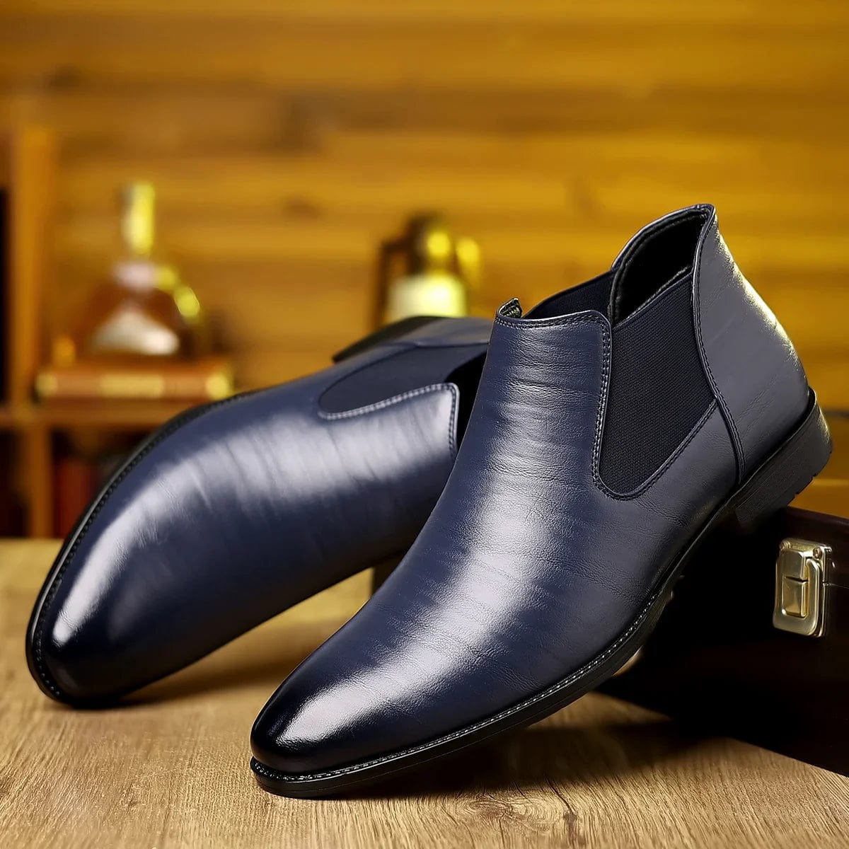 Scarpe eleganti da uomo in pelle blu scuro, stile Chelsea, su sfondo di legno. Calzature formali di lusso, moda maschile, design moderno.