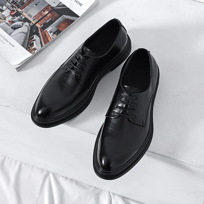 Scarpe eleganti nere in pelle da uomo su sfondo bianco, stile classico con lacci, ideali per abbigliamento formale e occasioni speciali.