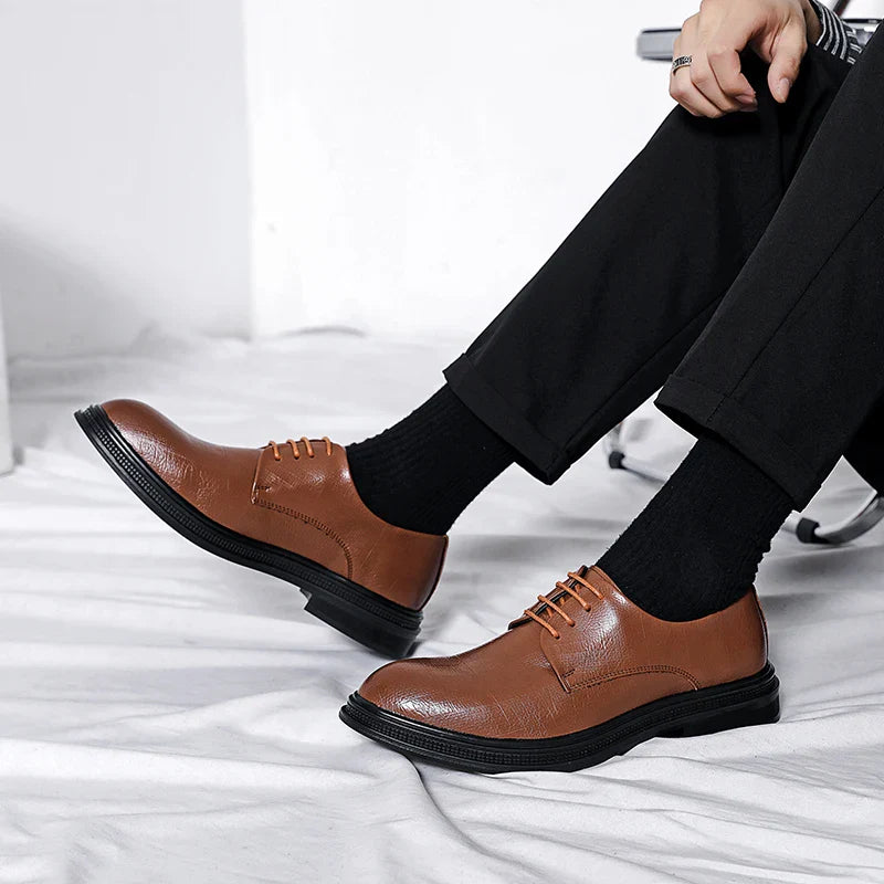 Scarpe eleganti uomo in pelle marrone, suola nera, indossate con pantaloni neri. Design classico, ideale per abbigliamento formale e business.