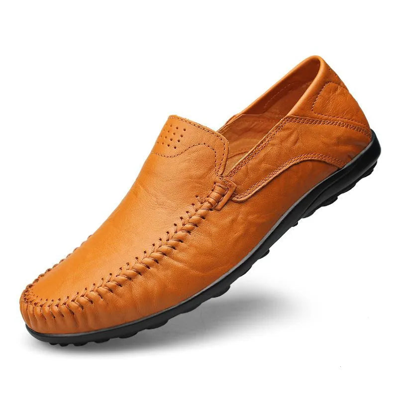 Scarpa mocassino in pelle marrone chiaro, suola nera antiscivolo, design elegante e casual, ideale per uomo, comfort e stile quotidiano.