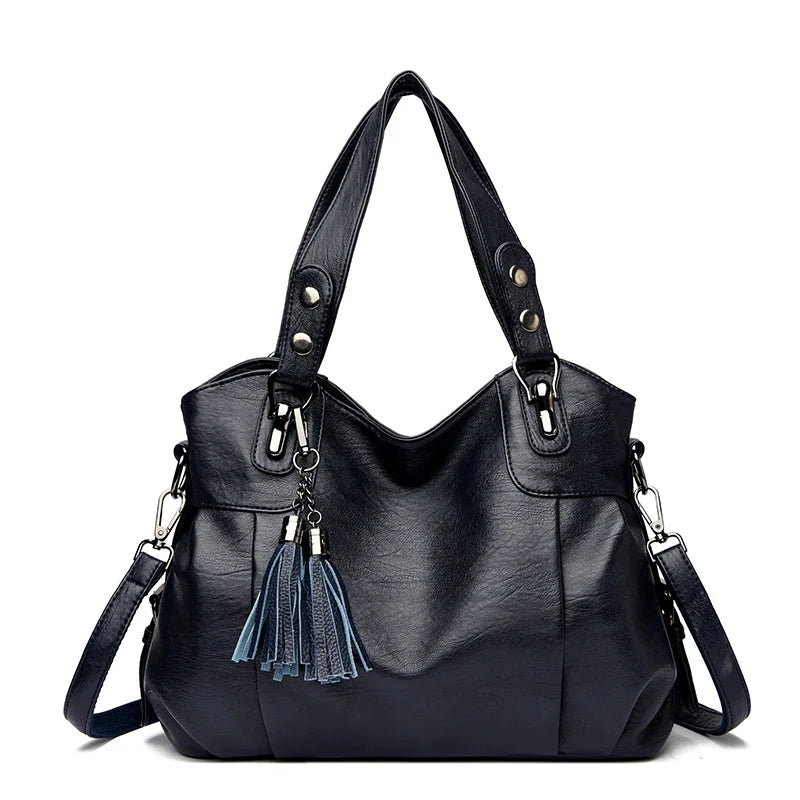 Borsa a spalla in pelle nera con manici e tracolla regolabile, decorata con nappine blu. Design elegante e moderno per donna.