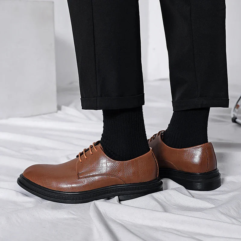 Scarpe eleganti uomo in pelle marrone, suola nera, abbinate a pantaloni neri. Calzature classiche per look formale e moderno.