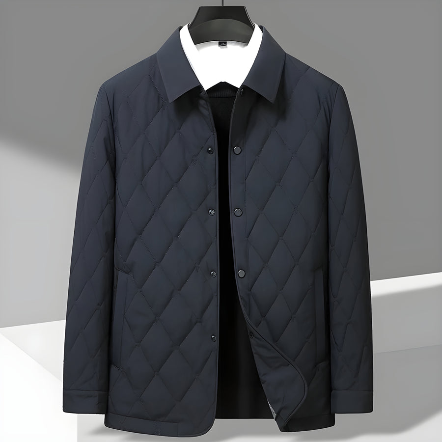 Giacca trapuntata blu scuro su appendiabiti, design elegante e moderno, ideale per moda uomo autunno inverno, abbigliamento casual chic.