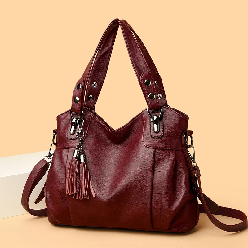 Borsa a mano in pelle marrone con dettagli metallici e nappine, design elegante e spazioso, perfetta per moda donna e accessori di tendenza.