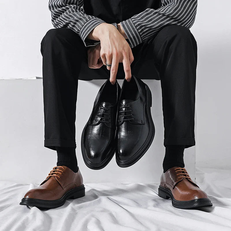 Uomo seduto con pantaloni neri, tiene scarpe eleganti nere, indossa scarpe marroni. Scarpe classiche da uomo, moda calzature eleganti.
