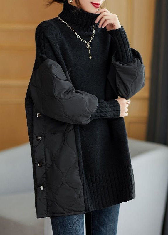 Maglione nero oversize con maniche imbottite e bottoni laterali, indossato da una donna. Stile casual chic, perfetto per l'autunno inverno.