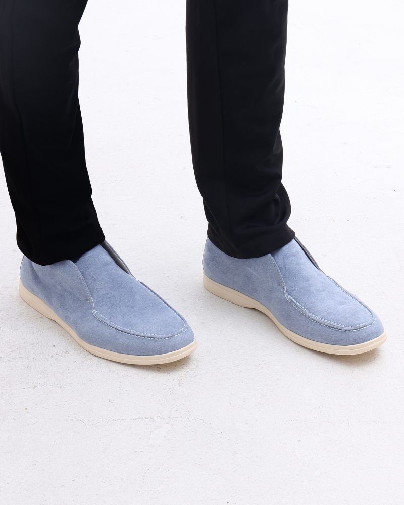 Scarpe mocassini uomo in camoscio azzurro, eleganti e casual, abbinate a pantaloni neri. Calzature moda maschile, stile moderno e confortevole.