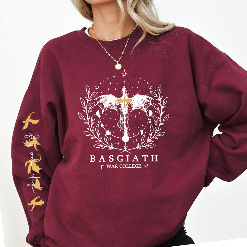 Felpa bordeaux con grafica fantasy di drago e scritta "BASGIATH WAR COLLEGE", dettagli dorati sulle maniche. Moda casual, abbigliamento fantasy.