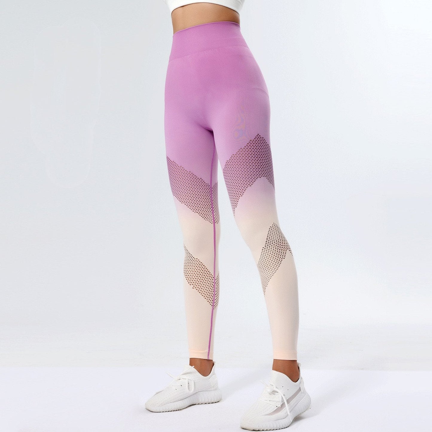 Leggings sportivi donna rosa e bianchi con motivo geometrico, indossati con scarpe da ginnastica bianche. Abbigliamento fitness alla moda.