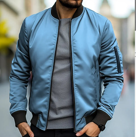 Giacca bomber blu uomo, stile casual, indossata su maglia grigia. Moda urbana, abbigliamento maschile autunnale, tendenza giacche leggere.