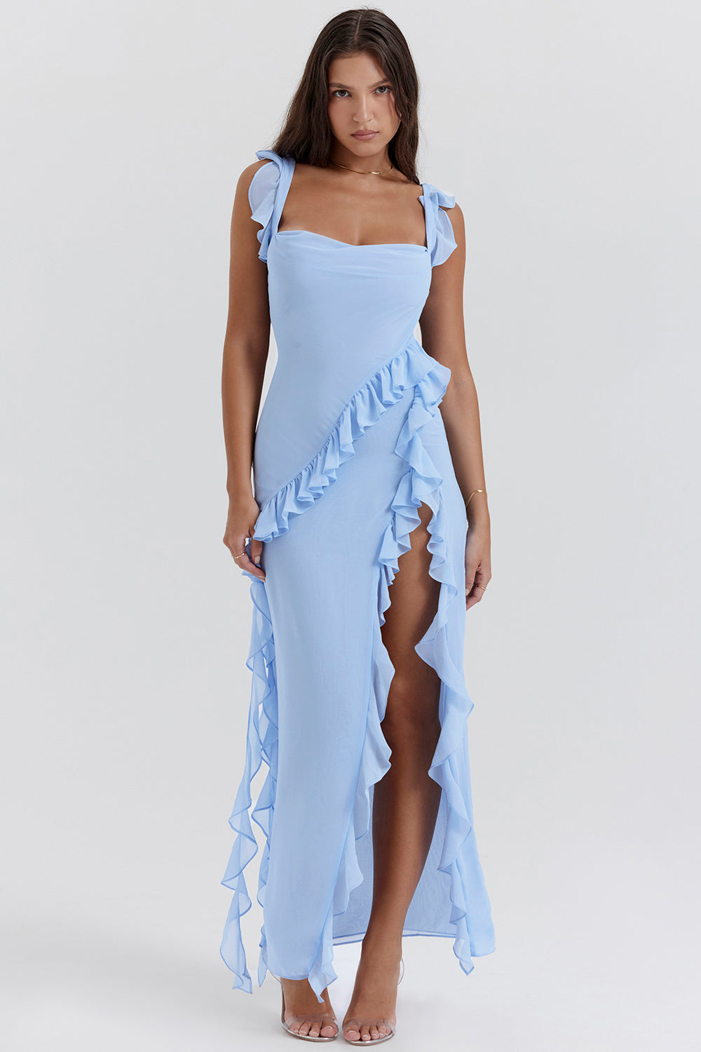 Donna in abito lungo azzurro con volant, spacco laterale e spalline annodate. Elegante vestito estivo, moda femminile, abbigliamento chic.