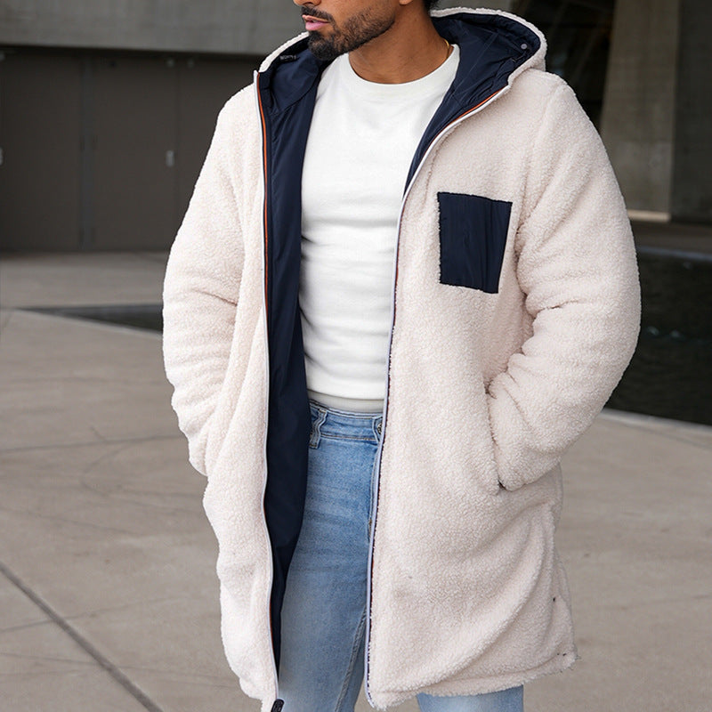 Uomo con cappotto in pile bianco, tasca blu, indossa jeans chiari e maglietta bianca. Moda invernale casual, abbigliamento caldo e confortevole.