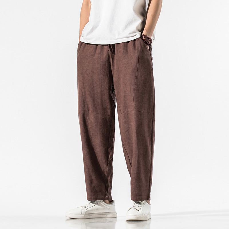 Pantaloni larghi marroni da uomo, stile casual, indossati con t-shirt bianca e sneakers bianche. Moda maschile, abbigliamento comodo.