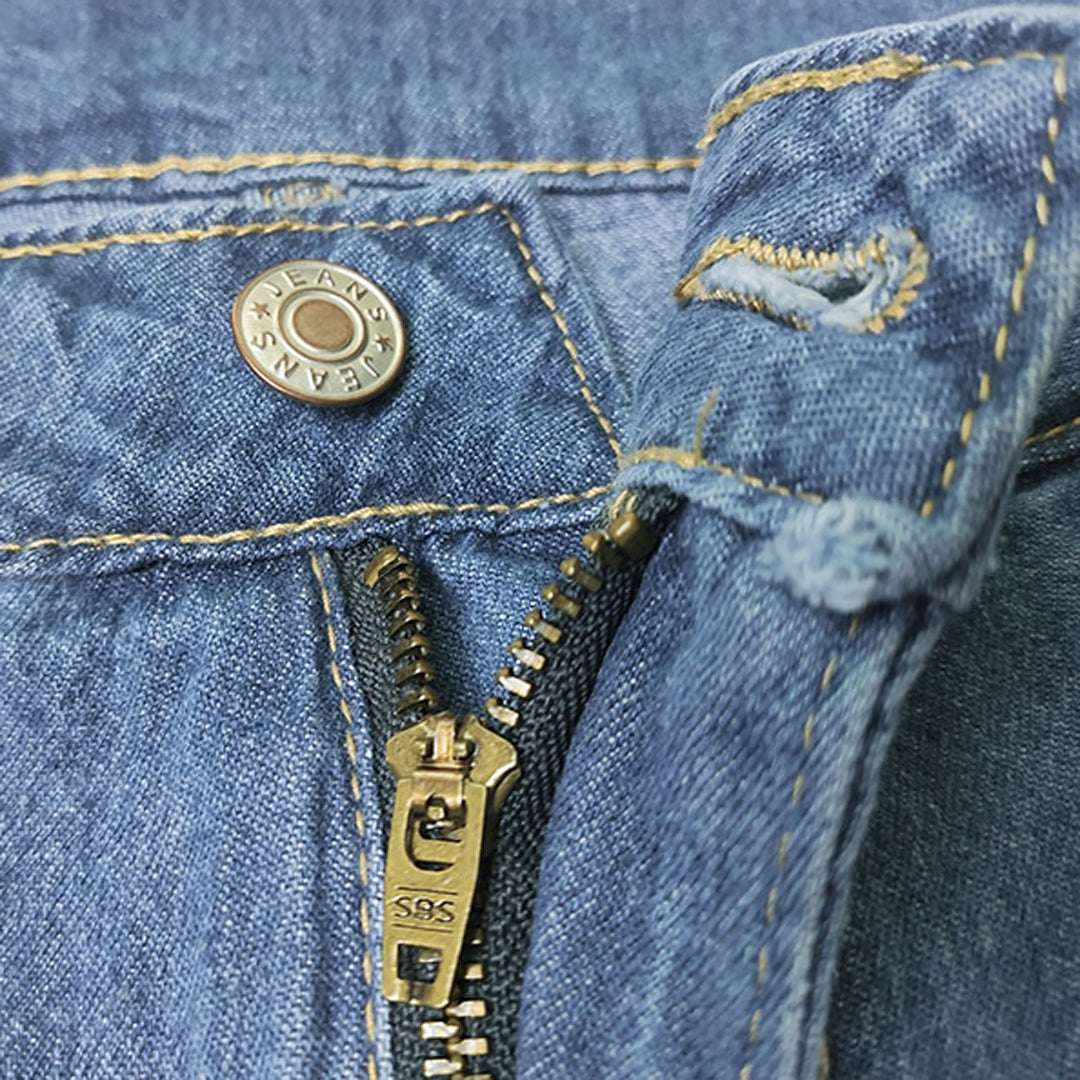 Jeans blu con cerniera dorata aperta e bottone metallico inciso "JEANS". Tessuto denim con cuciture gialle. Moda casual, abbigliamento uomo/donna.