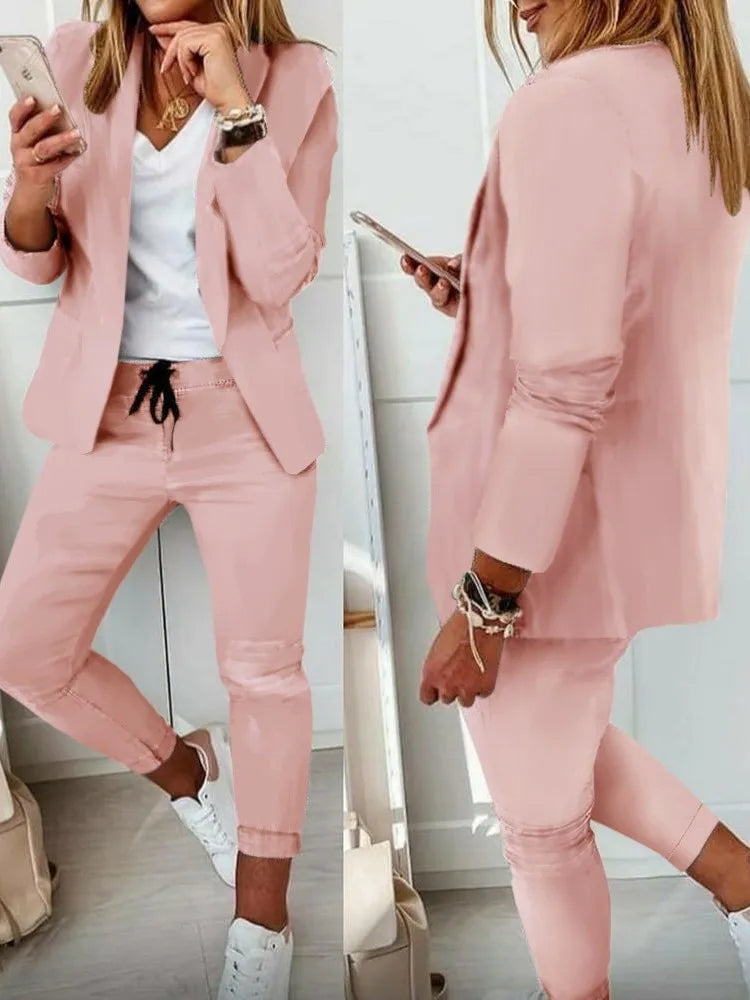 Completo donna rosa elegante, giacca e pantaloni, abbinato a t-shirt bianca e sneakers. Moda casual chic, outfit primaverile, stile moderno.