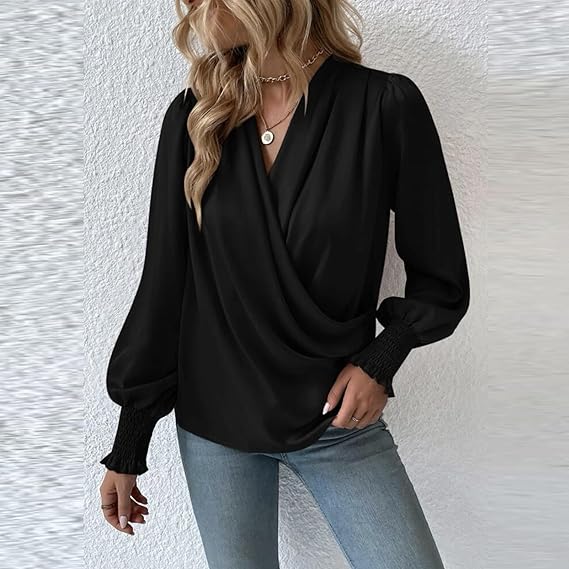 Donna con camicetta nera elegante, maniche lunghe a sbuffo, abbinata a jeans chiari. Stile moda casual chic, collana dorata.