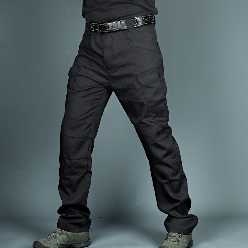 Pantaloni tattici neri da uomo, con tasche cargo e cintura, indossati con scarponi verdi. Abbigliamento militare resistente e funzionale.