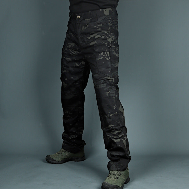 Pantaloni tattici mimetici neri, indossati con stivali verdi. Abbigliamento militare resistente, ideale per outdoor e attività avventurose.