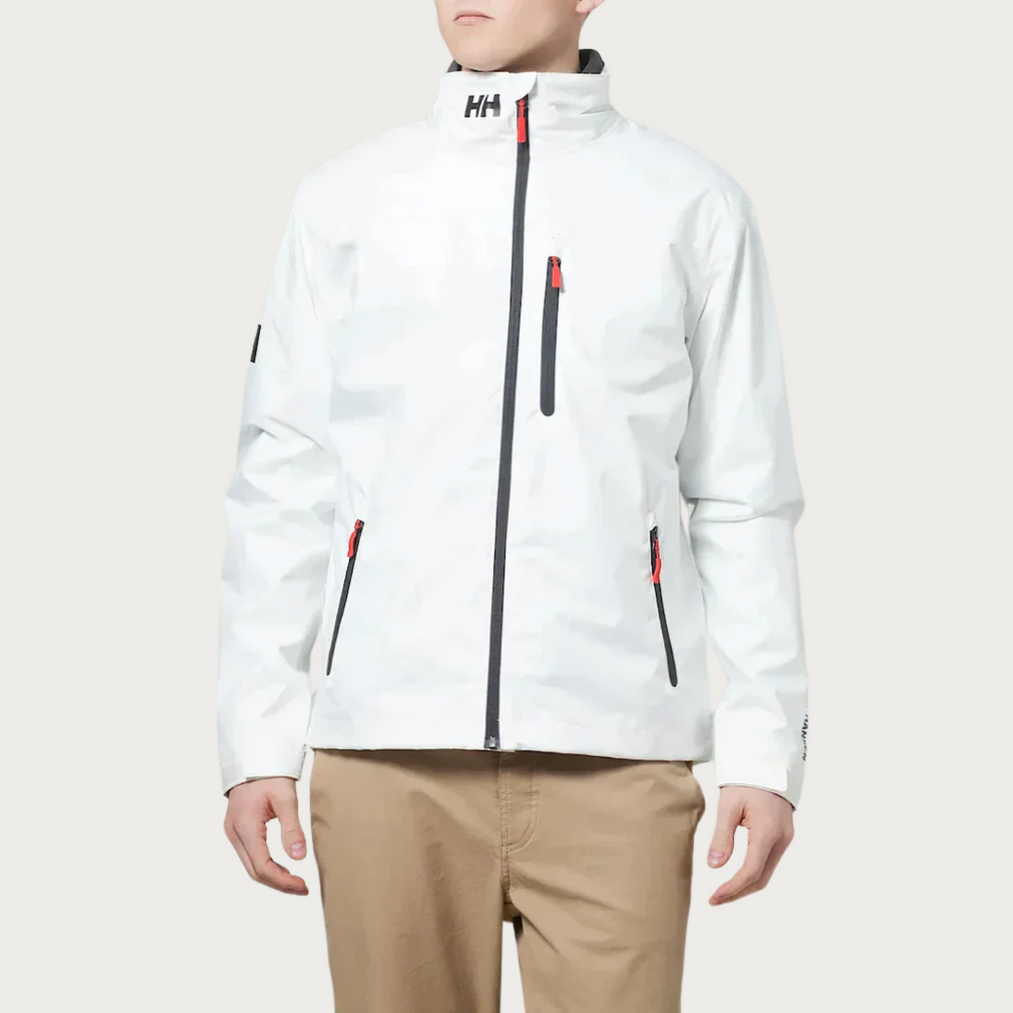Giacca impermeabile bianca Helly Hansen da uomo, con zip nera e dettagli rossi, ideale per attività outdoor. Design moderno e funzionale.