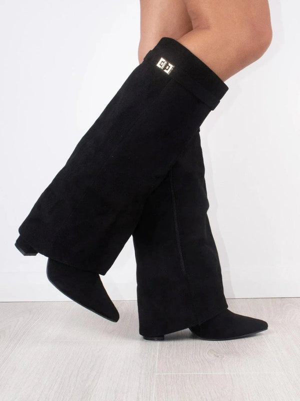 Stivali alti neri in camoscio con tacco basso, design elegante, su pavimento in legno chiaro. Accessorio moda autunno-inverno.