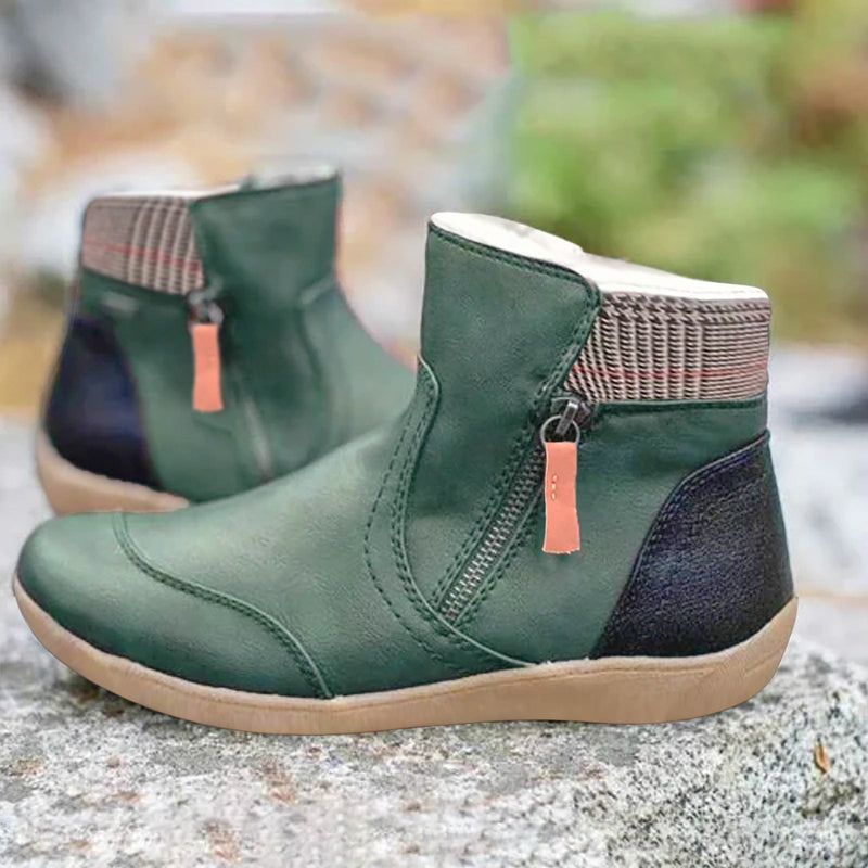 Stivaletti verdi in pelle con cerniera laterale, suola in gomma beige e dettagli a righe sul collo. Scarpe moda autunno donna, comode e casual.