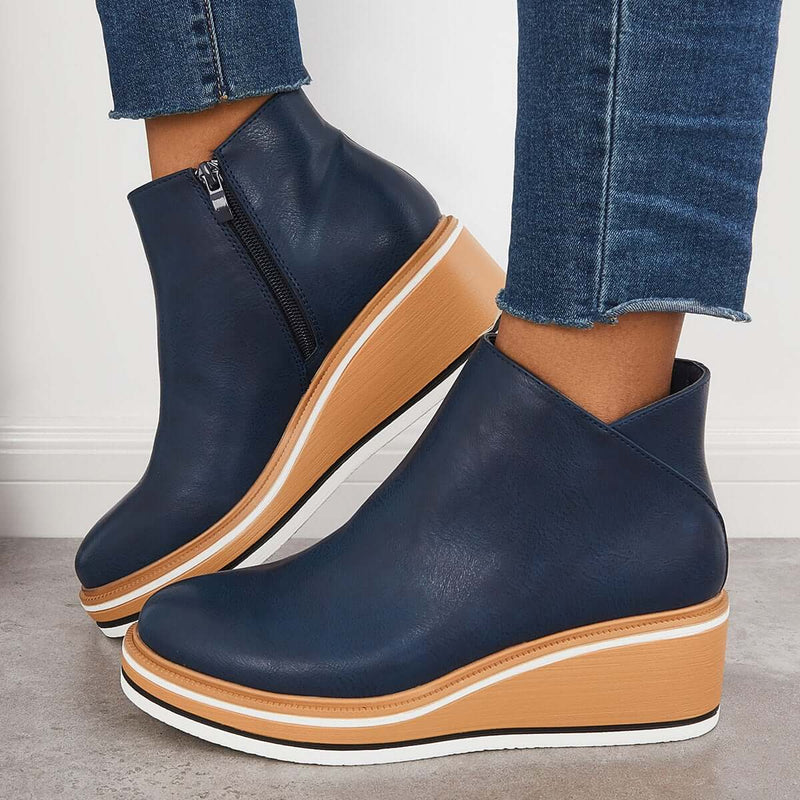 Stivaletti blu con zeppa in legno, zip laterale, indossati con jeans. Scarpe moda donna, calzature autunno, stile casual chic.